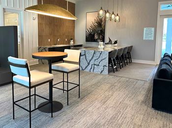 a kitchen with a marble counter top and a bar with chairs